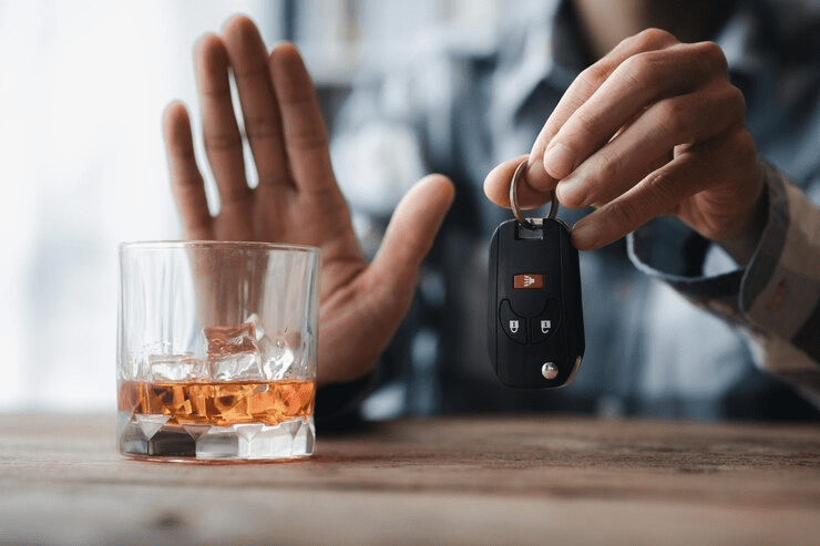 Man holding a glass of brandy he is drinking brandy in a bar drinking alcohol impairs driving ability and can damage health The concept of drinking alcohol