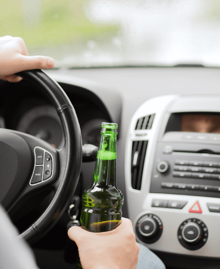 man drinking alcohol while driving the car